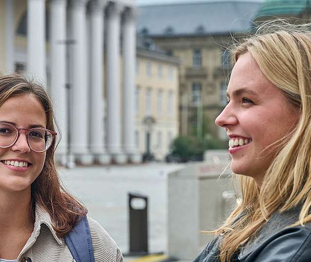 Zwei Studentinnen stehen auf dem Karlsruher Marktplatz.