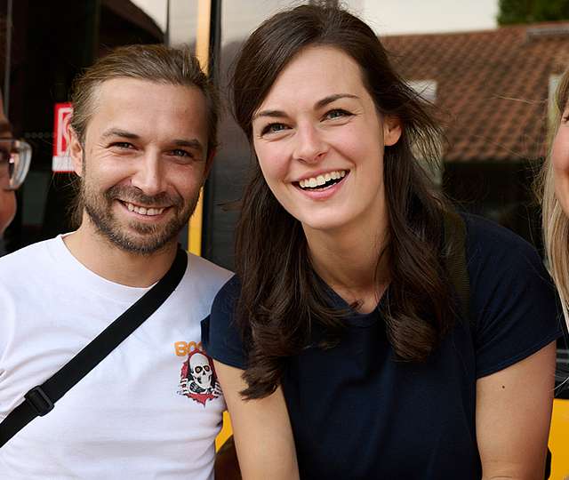 4 junge Menschen stehen lächelnd zusammen.