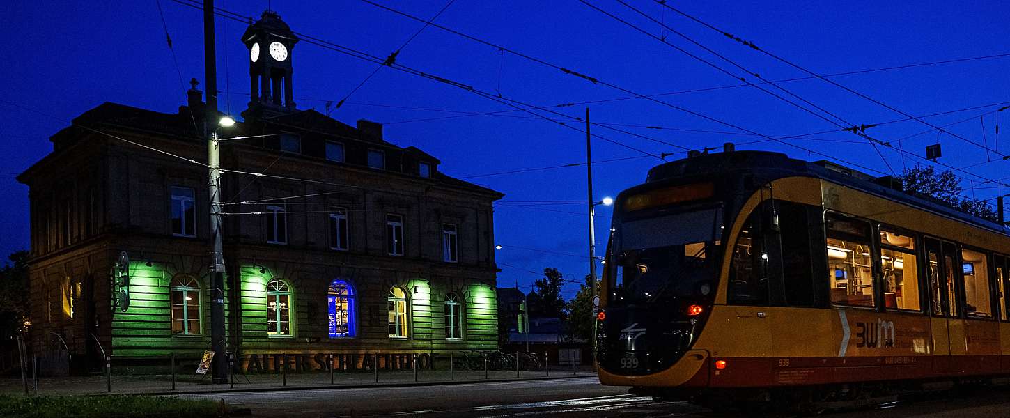 Eine KVV-Bahn fährt nachts durch die Karslruher Stadt.