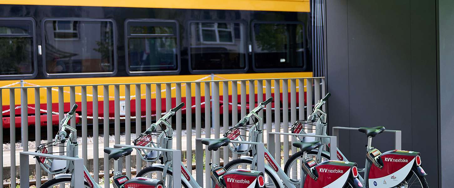 An einer Bahn-Haltestelle stehen KVV.nextbikes aufgereiht.