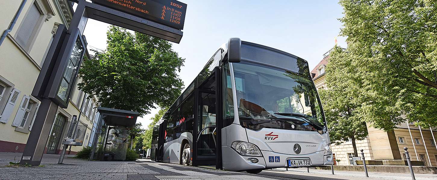 Ein Bus des KVV steht an einer Bushaltestelle.