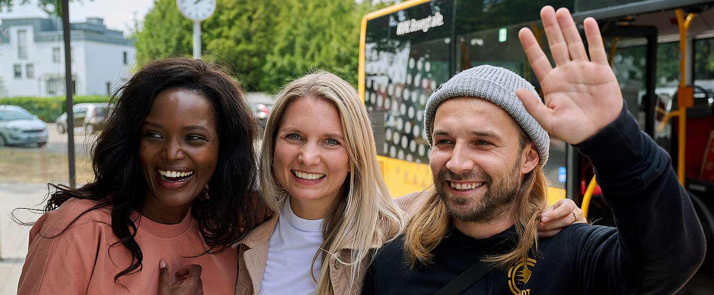 Drei Kinder stehen im Kreis und halten sich gegenseitig.