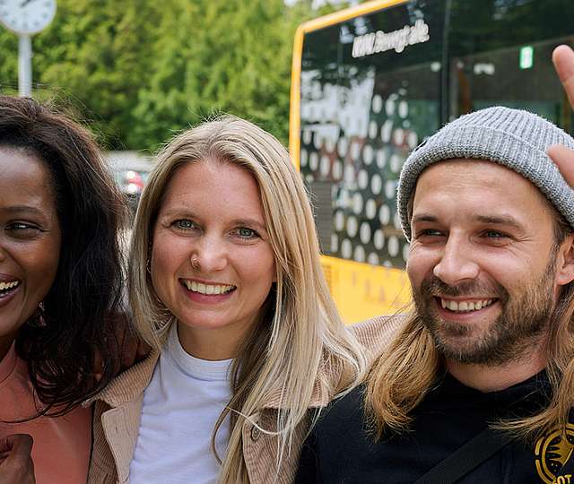 Drei Kinder stehen im Kreis und halten sich gegenseitig.