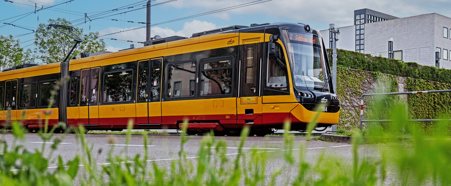 Ein Mann sitzt vor einer Wand voller Bildschirme und telefoniert. Die Bildschirme zeigen Fahrpläne.